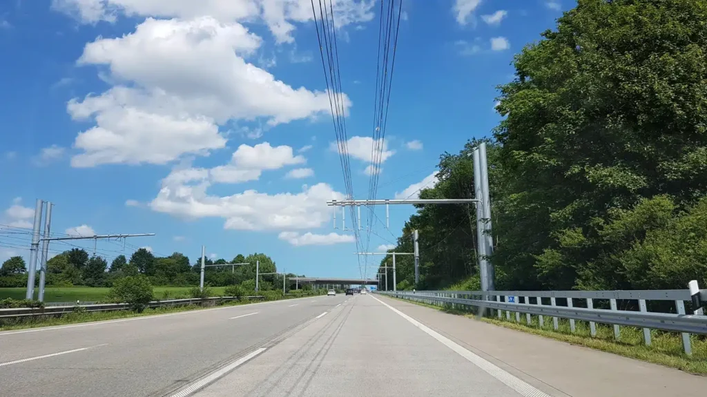 Elektromobilität - Die Strecke zwischen Frankfurt am Main und Darmstadt auf der Autobahn 5 gehört zu den verkehrsreichsten Routen in Deutschland. Entlang der Fahrbahn sind 400 Masten positioniert, die Oberleitungen über die rechten Spuren halten